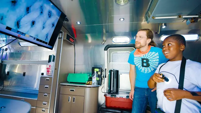 Students learn about science using microscopes on the BioBus.